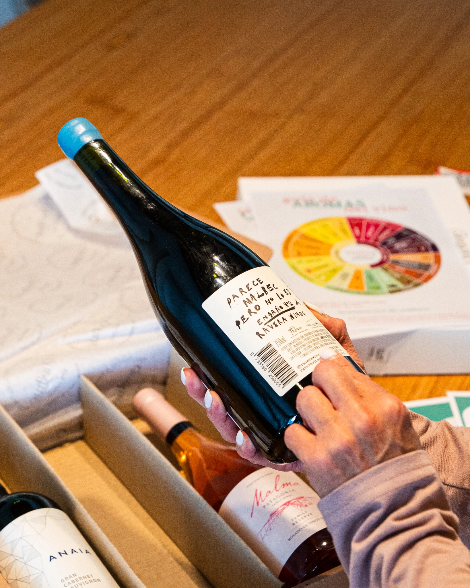 Botella de vino sostenida con la mano al abrir el box